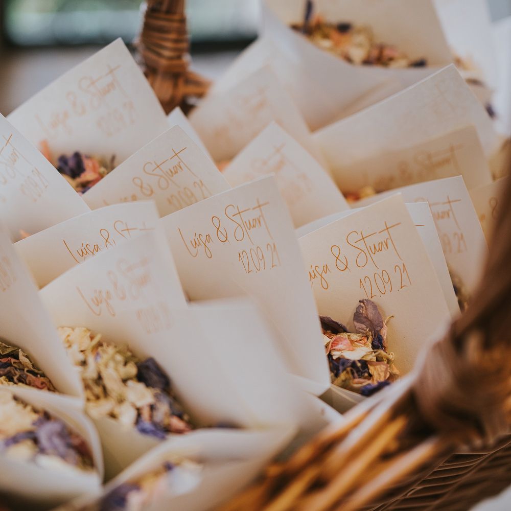 Confetti cones with dried confetti in woven wooden basket at wedding in Buckinghamshire