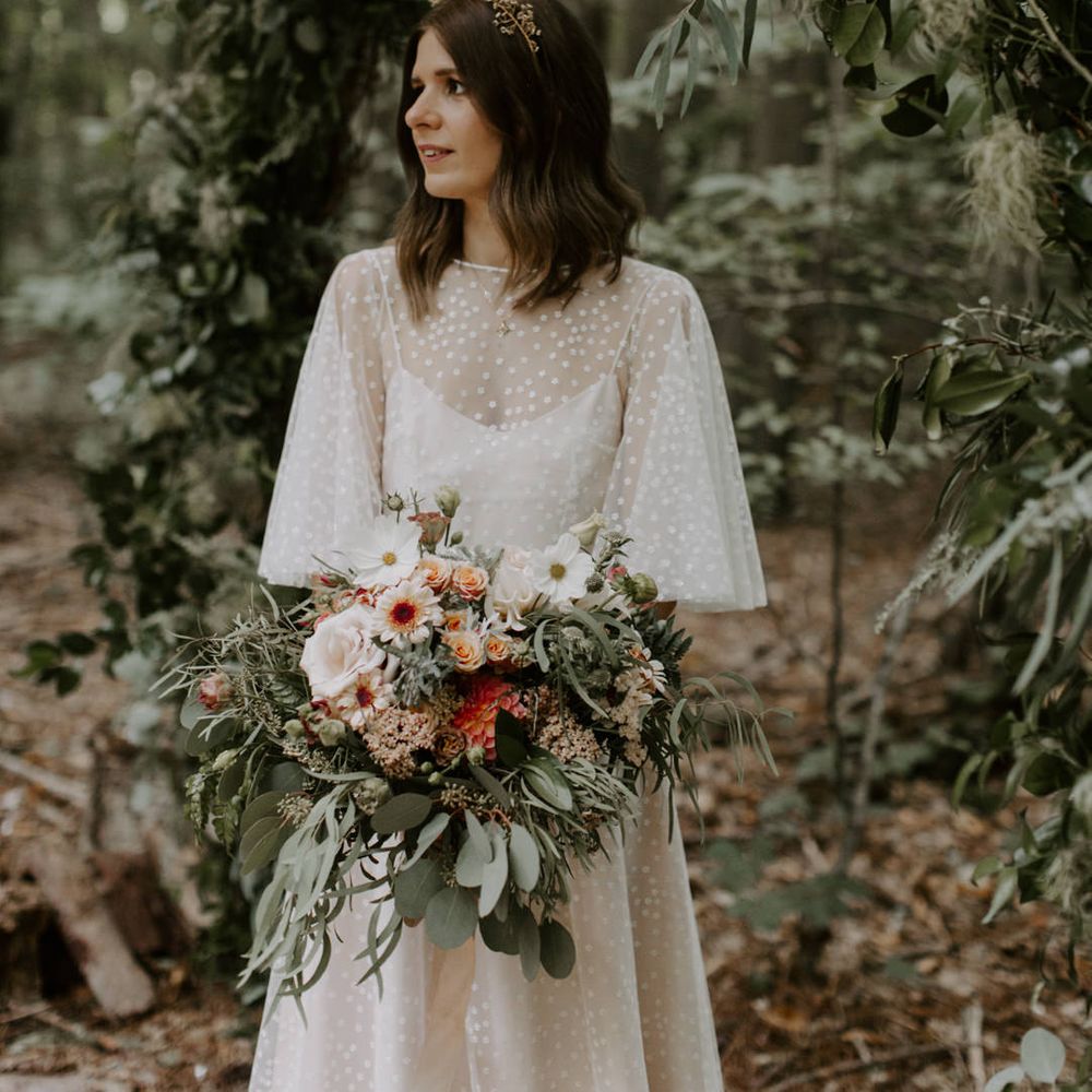 Bride holds her floral bouquet and looks away from camera