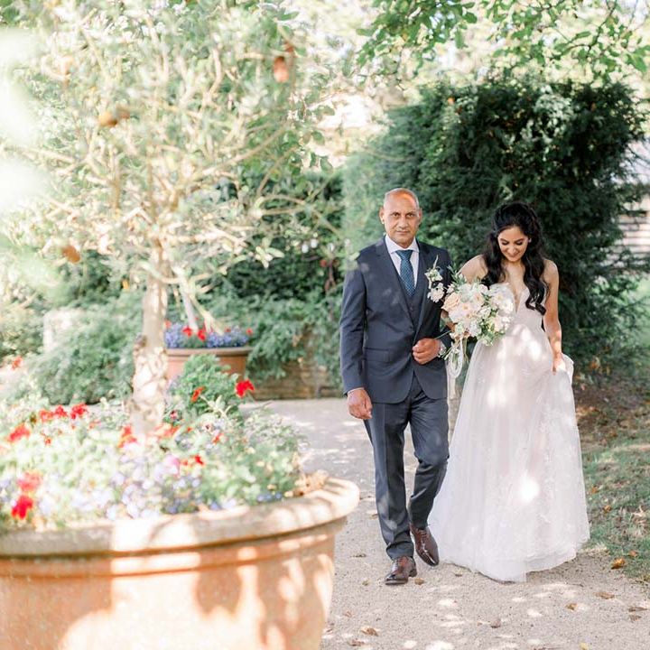Bride & her father walk together to the aisle on her wedding day