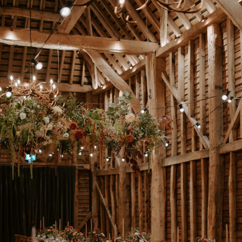 Festoon lighting and flower decor at barn venue