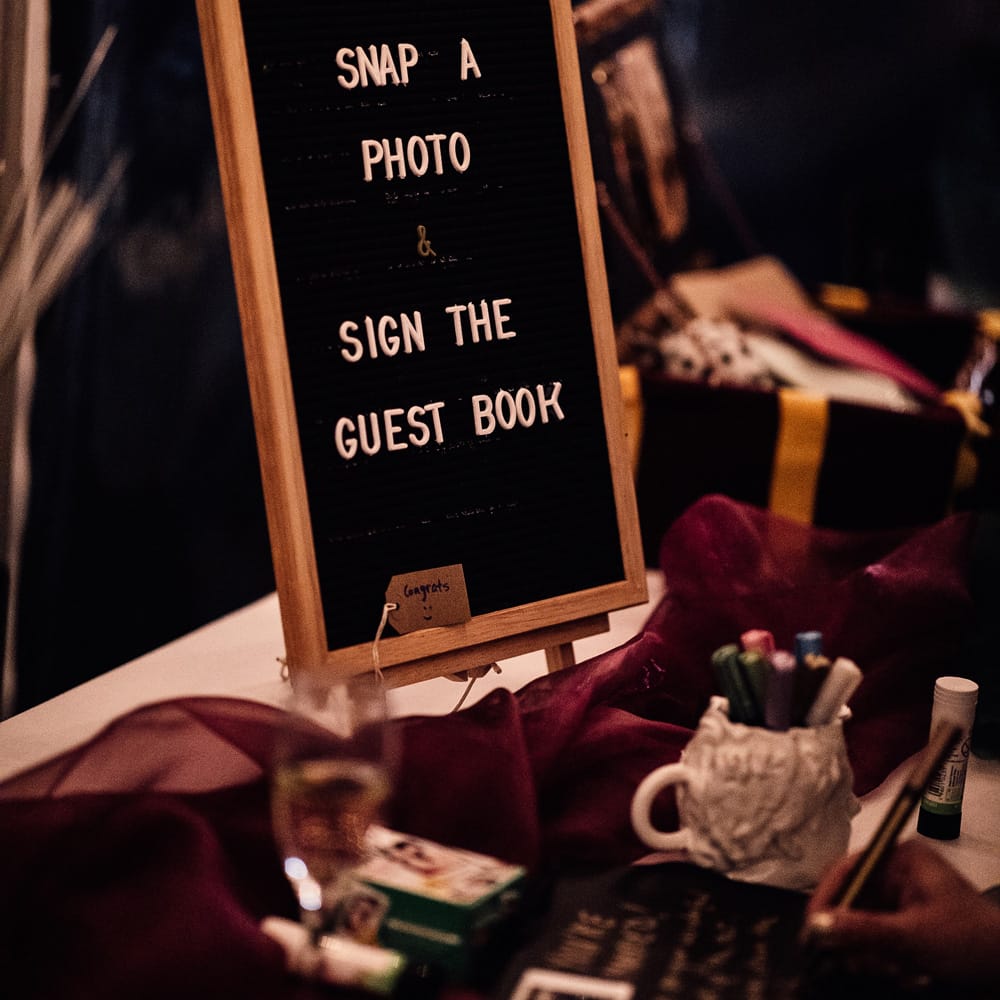 Polaroid guest book wedding sign on table at autumn wedding reception