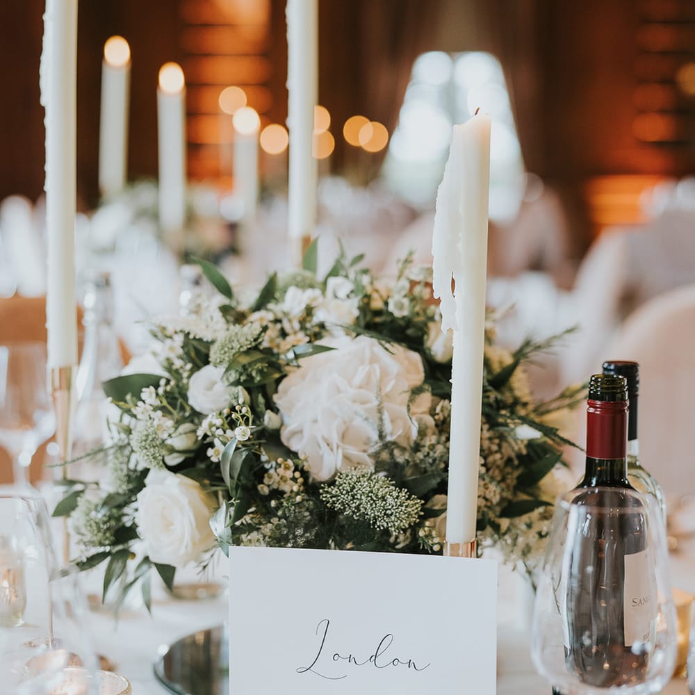 White candles and white rose wedding centrepiece table setting 
