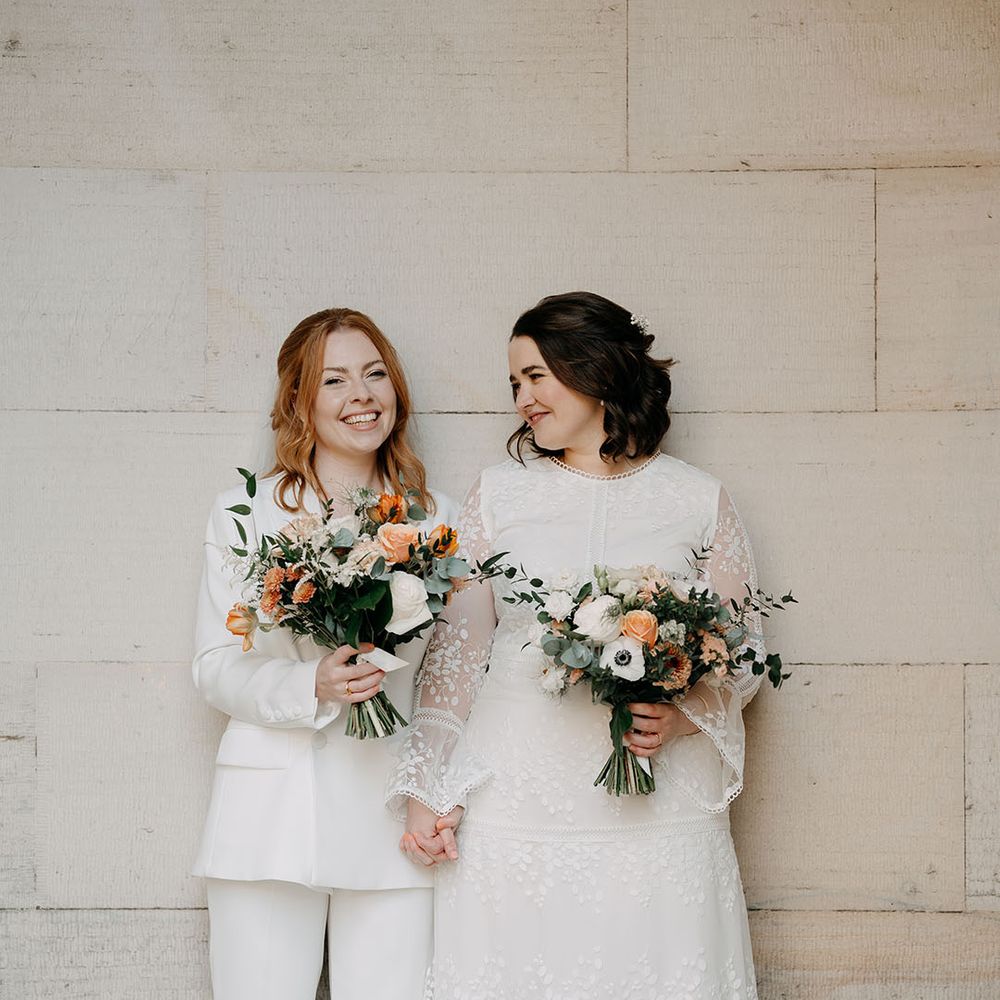 Brides look lovingly at one another during couples portraits in Edinburgh