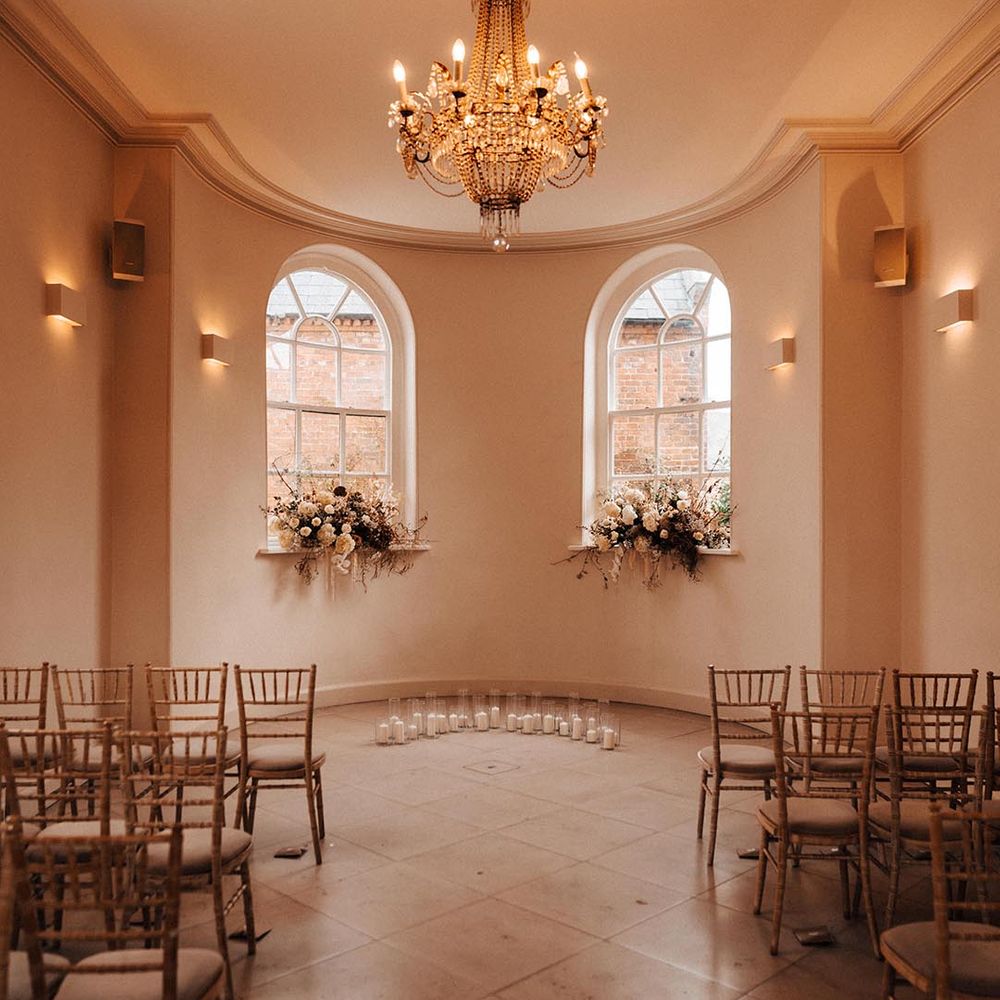 Reception room at Iscoyd Park with large chandelier and white rose floral arrangements