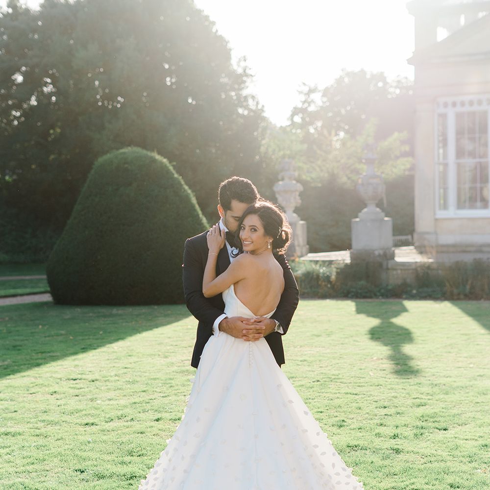 Bride wears Emma Beaumont design wedding dress with V shaped back and floral appliqué Princess skirt  