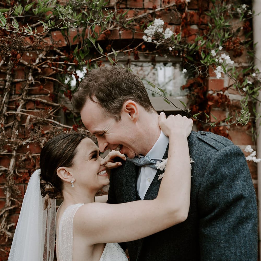 Bride in sparkly wedding dress embraces the groom closely as they smile at each other on their wedding day at Pimhill Barn 
