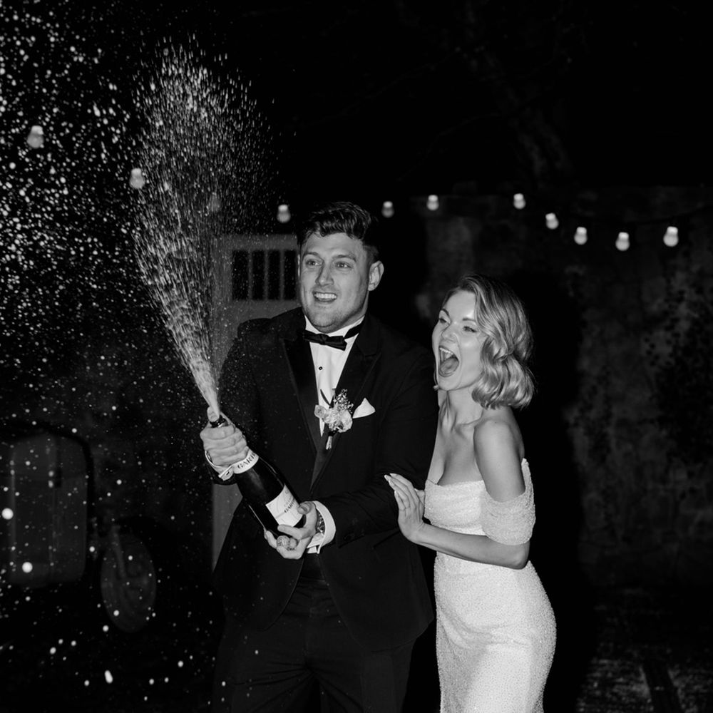 Wyresdale Park wedding with the bride and groom celebrating their wedding by popping some champagne 