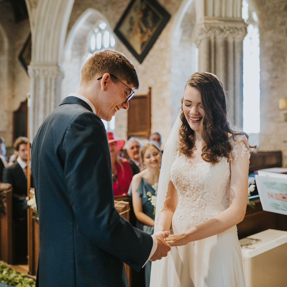 Groom puts on the wedding ring onto the bride's fingers for the Christian church ceremony