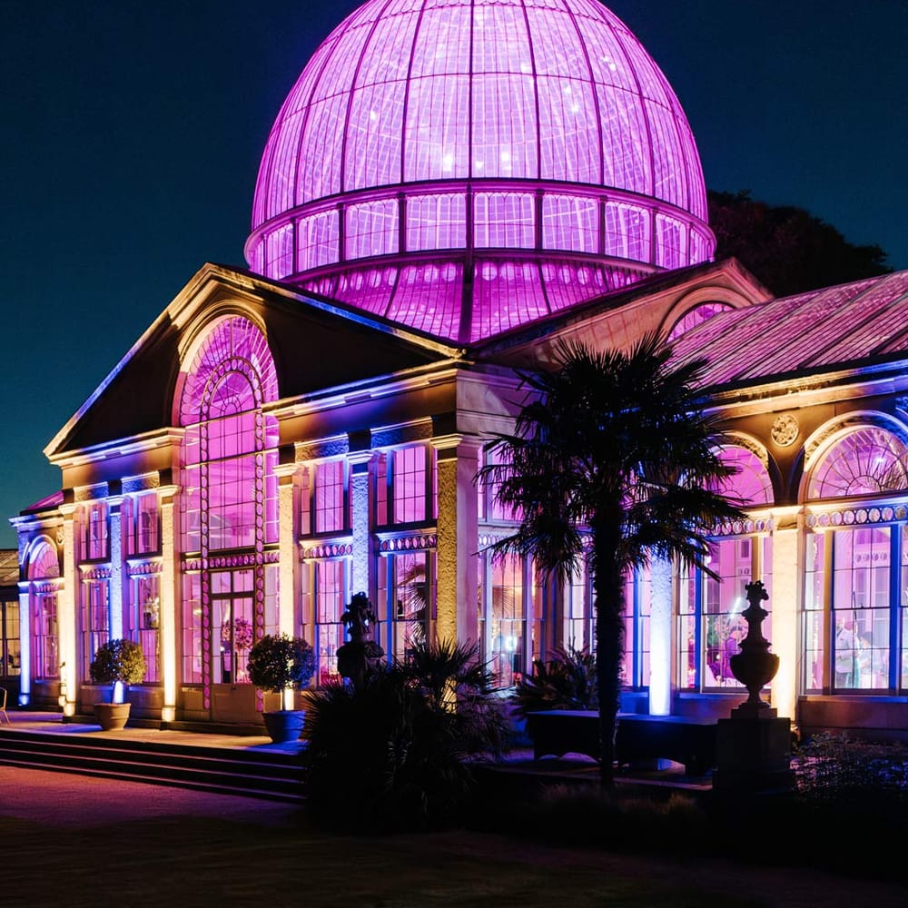 Exterior shot of Syon Park wedding venue with bright lights for 10 year vow renewal ceremony