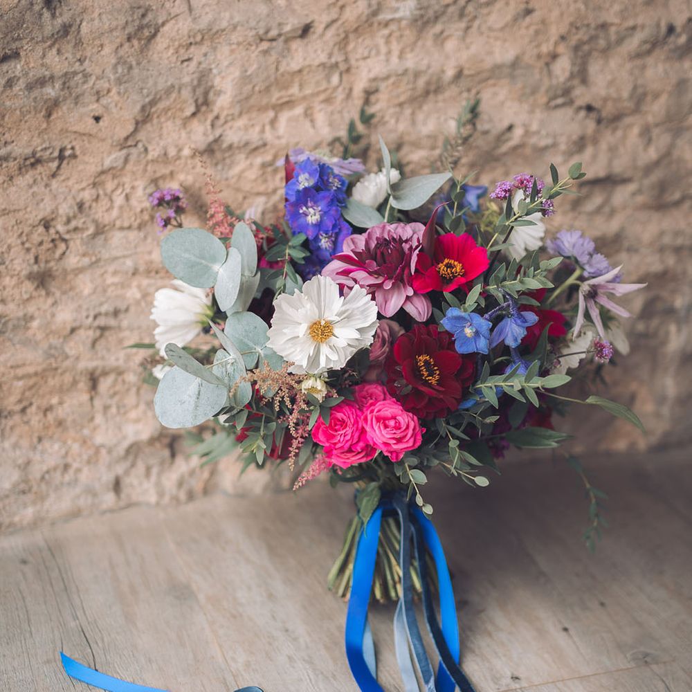 Dark pink, white and blue wedding bouquet tied with dark blue ribbon 