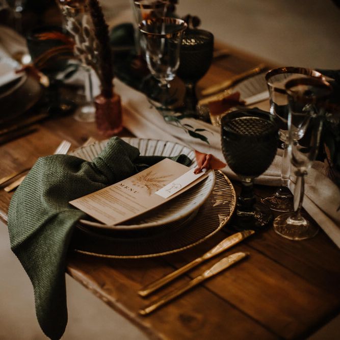 Boho wedding table decor with emerald green napkins 
