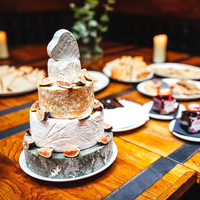 Cheese tower featuring chutneys on wooden table