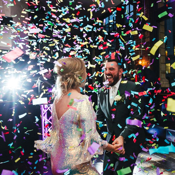 Confetti blows around bride & groom during reception