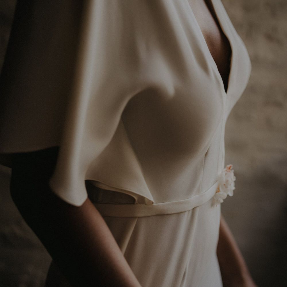 minimalist wedding dress in fluid crepe with plunging neckline and belt detail