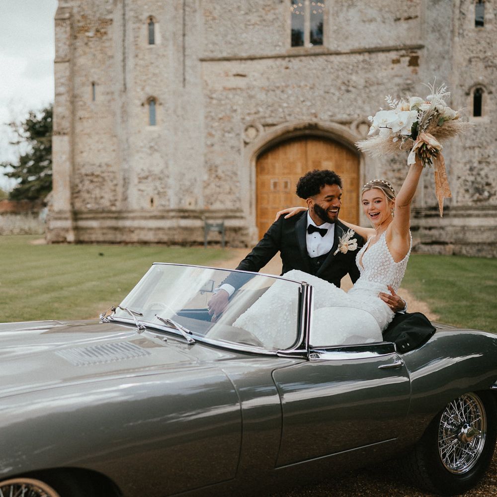 Bride and groom portrait in a classic grey wedding car for a modern luxury wedding 