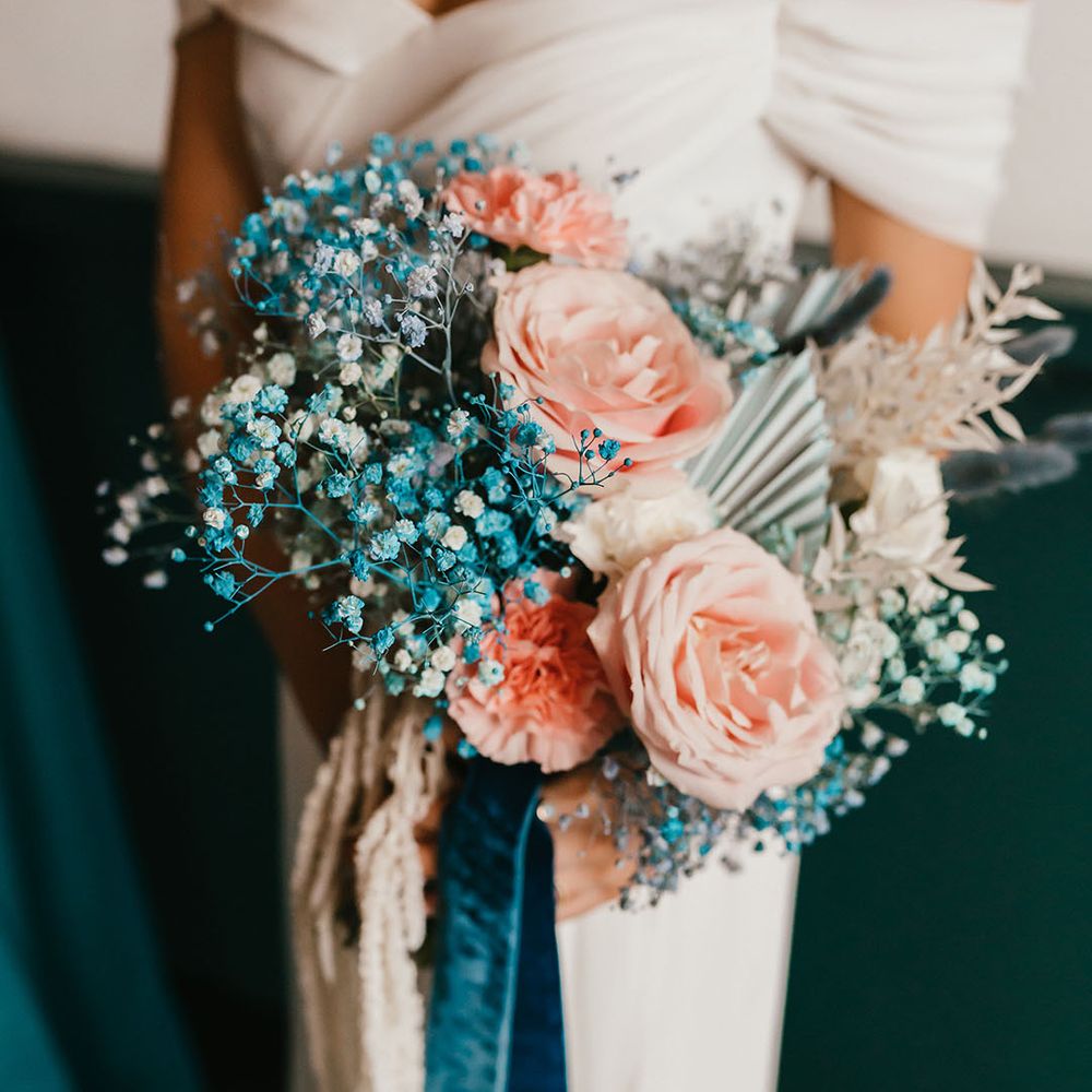 pink and teal wedding bouquet tied with ribbon including gypsophila and roses 