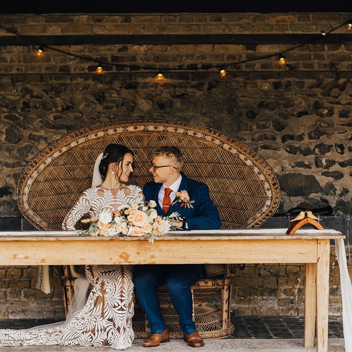 Boho wedding, Bride in long lace detailed dress with Groom in Navy suit with orange silk tie & Boutonniere 