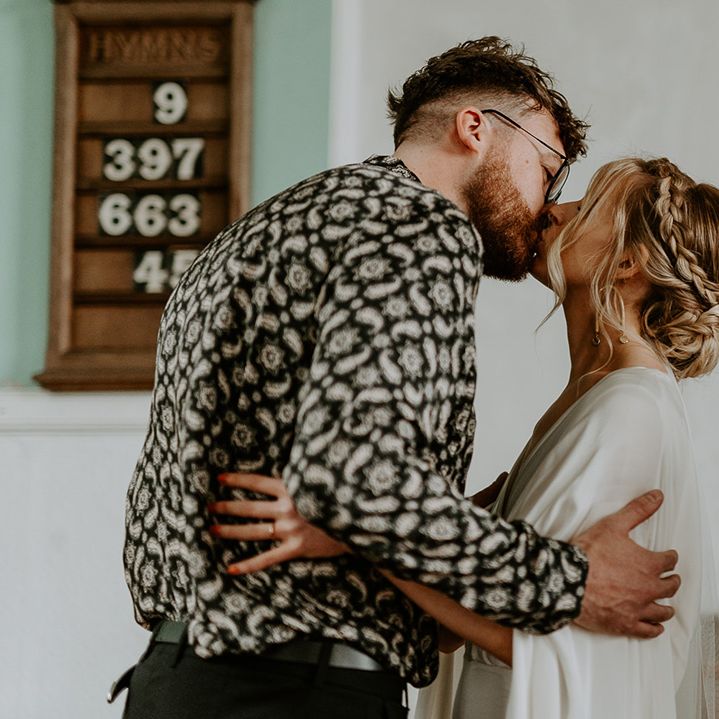 Bride & groom kiss during church ceremony