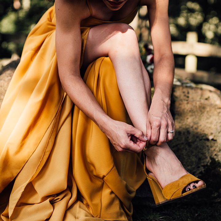 Bride does up her shoes on the morning of her wedding day