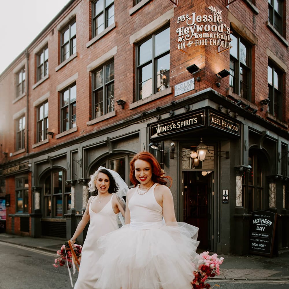 Bride in a Carrie Bradshaw tulle skirt dress with jersey top and satin slip wedding dress walking across the streets of Manchester 