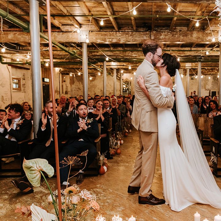 Bride and groom share their first kiss as a married couple at Holmes Mill wedding venue