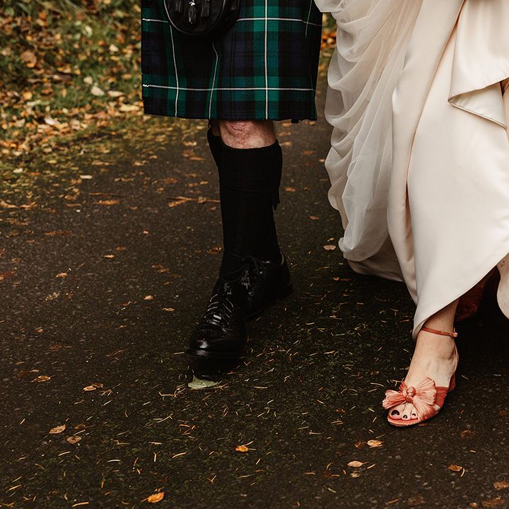 Bride's Loeffler Randall pink bow wedding shoes and groom's black shoes with knee high socks 