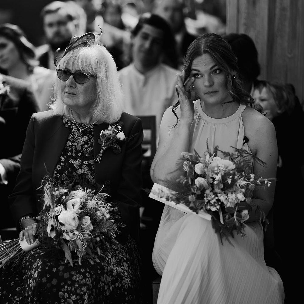 Bridesmaid wipes her eyes as she gets emotional during ceremony