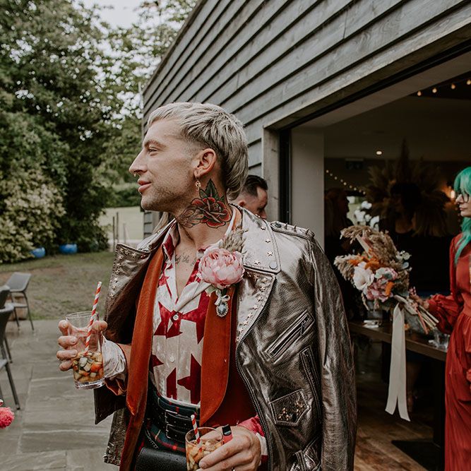 Groom wears colourful star shirt, orange velvet blazer and gold embellished leather jacket 