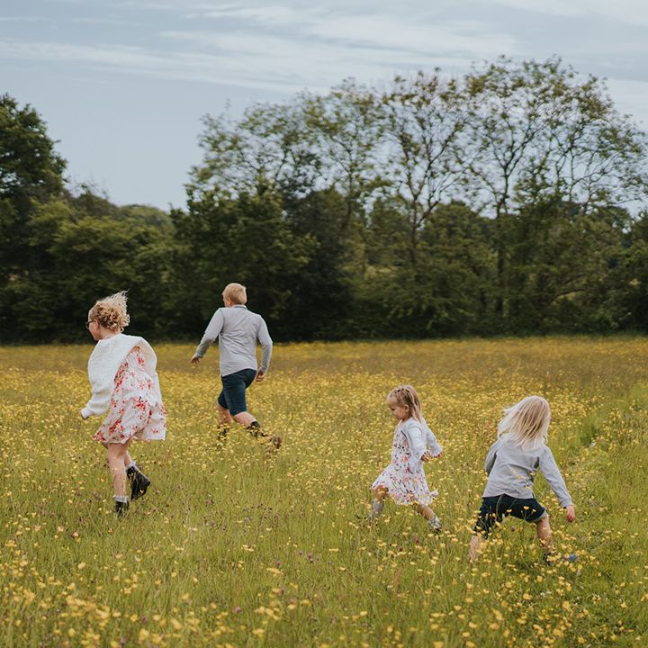 Children walk through fields at Burrow Farm Gardens wedding 