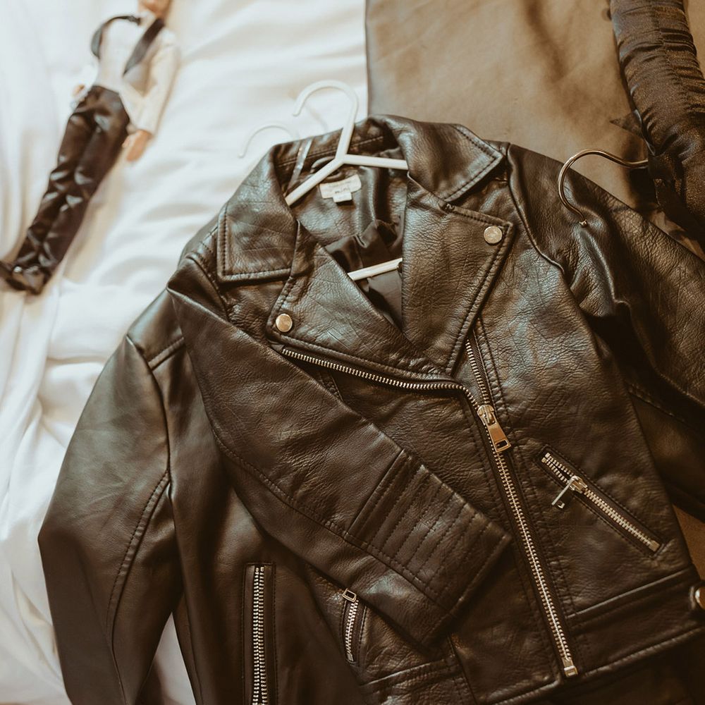 Matching bride and flower girl leather jackets with Disney motif for fun bouncy castle wedding 