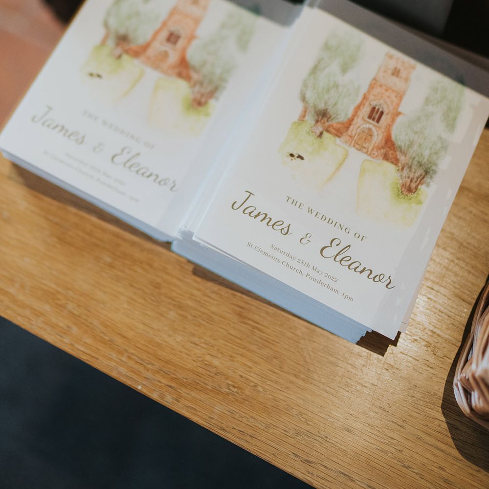 Order of service wedding booklets at the entrance to the church 