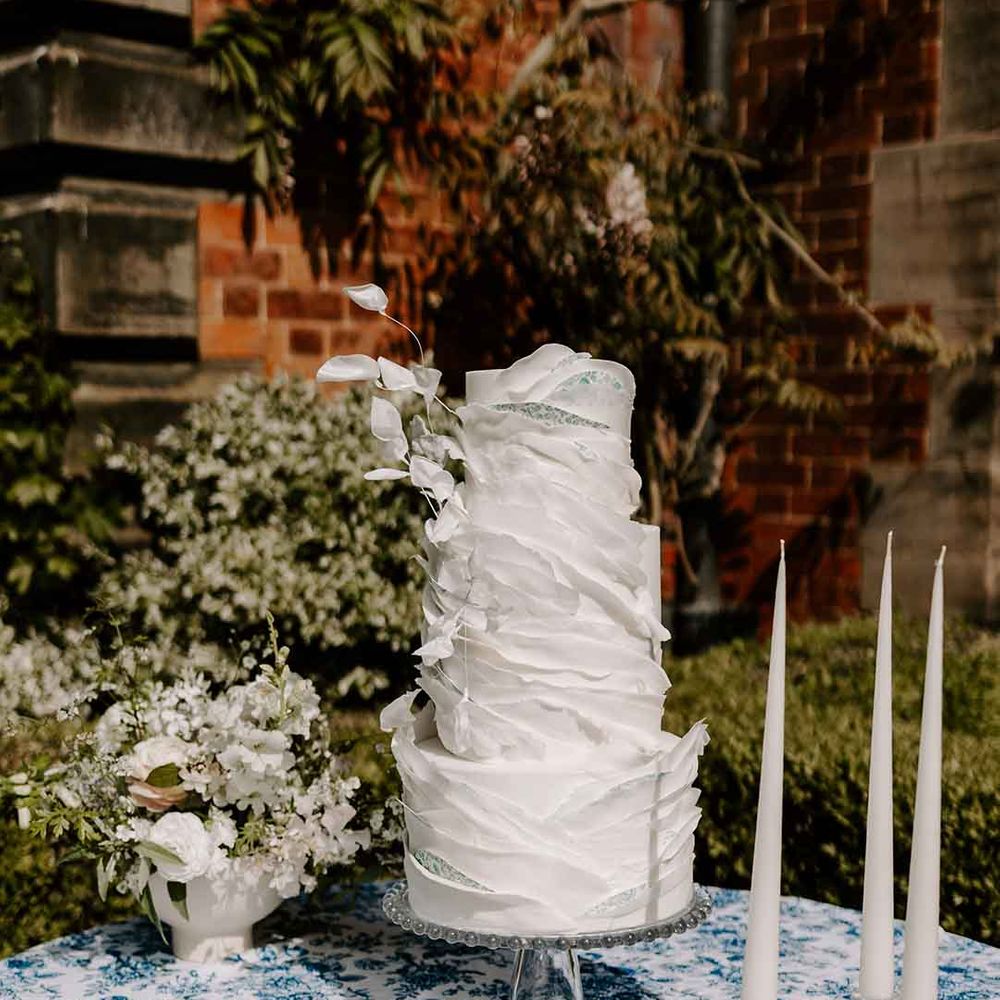 four tier iced wedding cake with layered design 