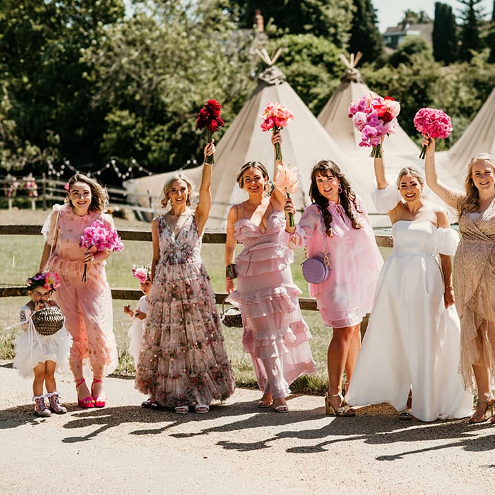 Bridal party wearing floral mismatched pink bridesmaid dresses 