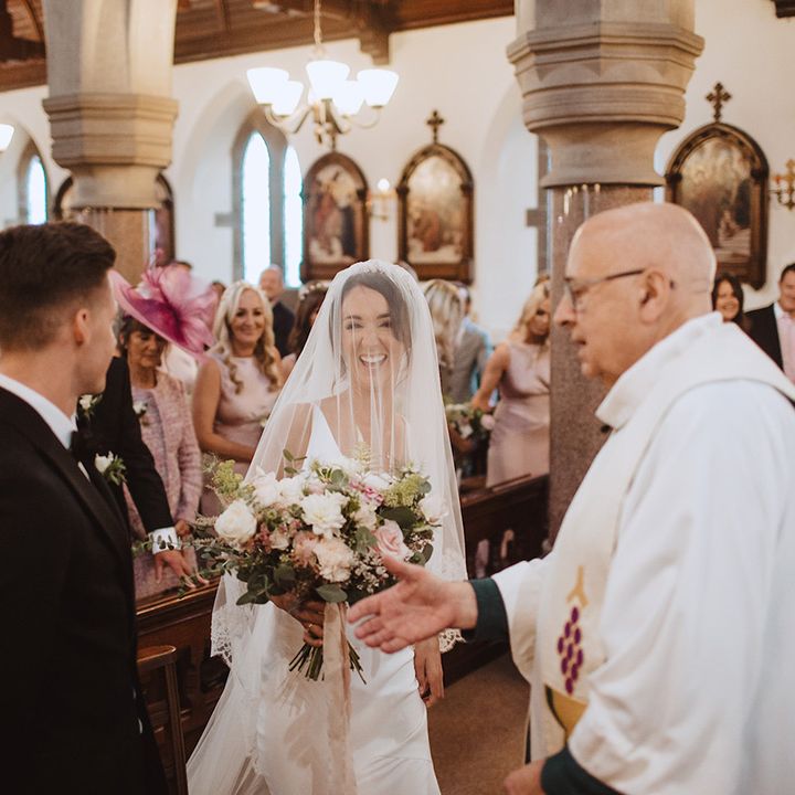 Catholic wedding ceremony with the bride and groom in traditional black tie attire 