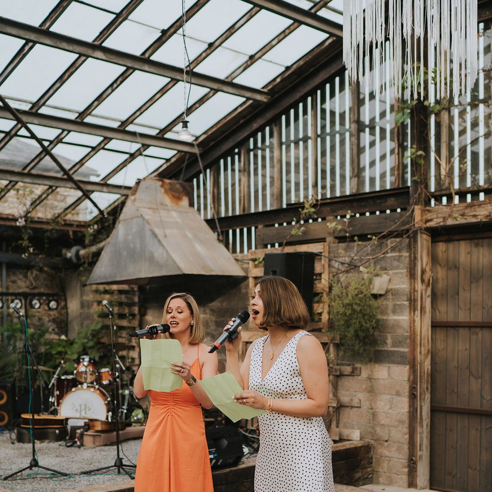 The two maids of honour perform a joint wedding speech for the bride and groom at glasshouse wedding 