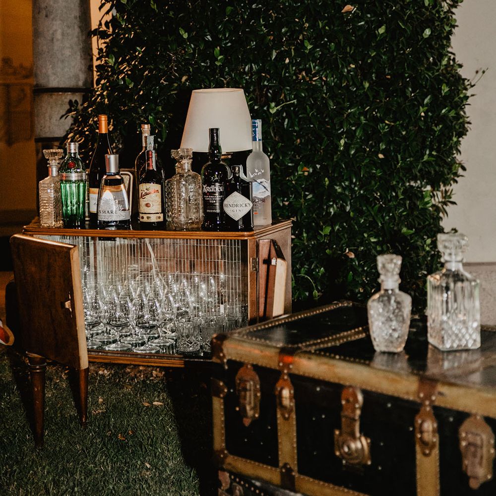 Unique cocktail cart with cart filled with empty glasses and spirits for guests with crystal decanters 