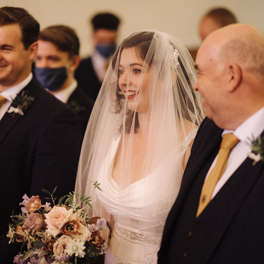 Bride & groom stand with wedding party in the Chapel 