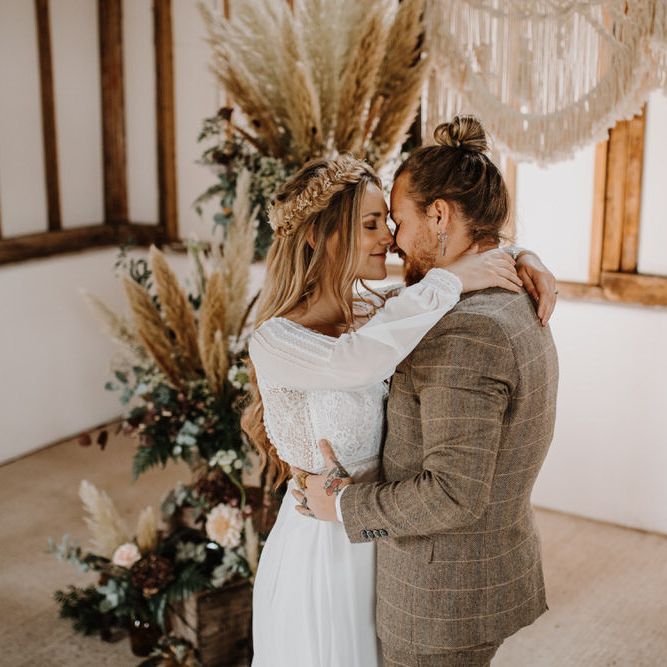 Bride and groom hugging at country barn wedding with boho wedding theme