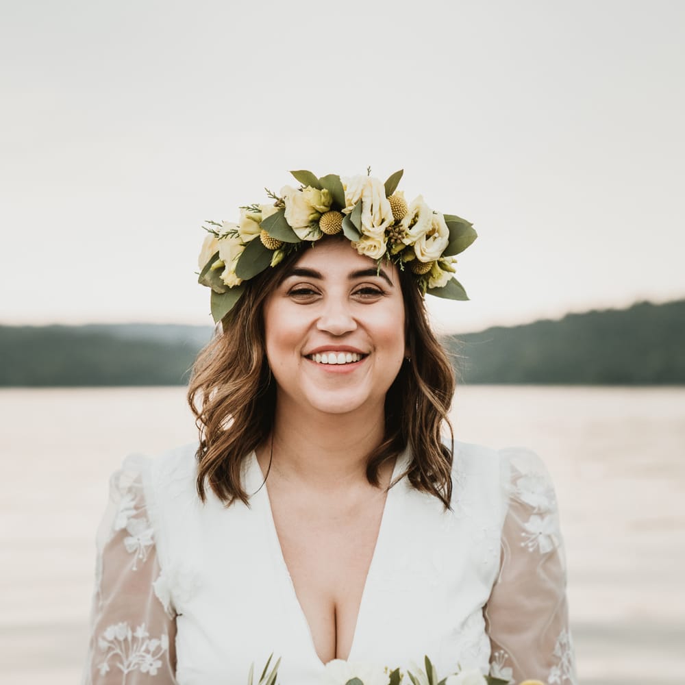Beautiful boho bride with wavy shoulder length hair wearing and green, white and yellow flower crown