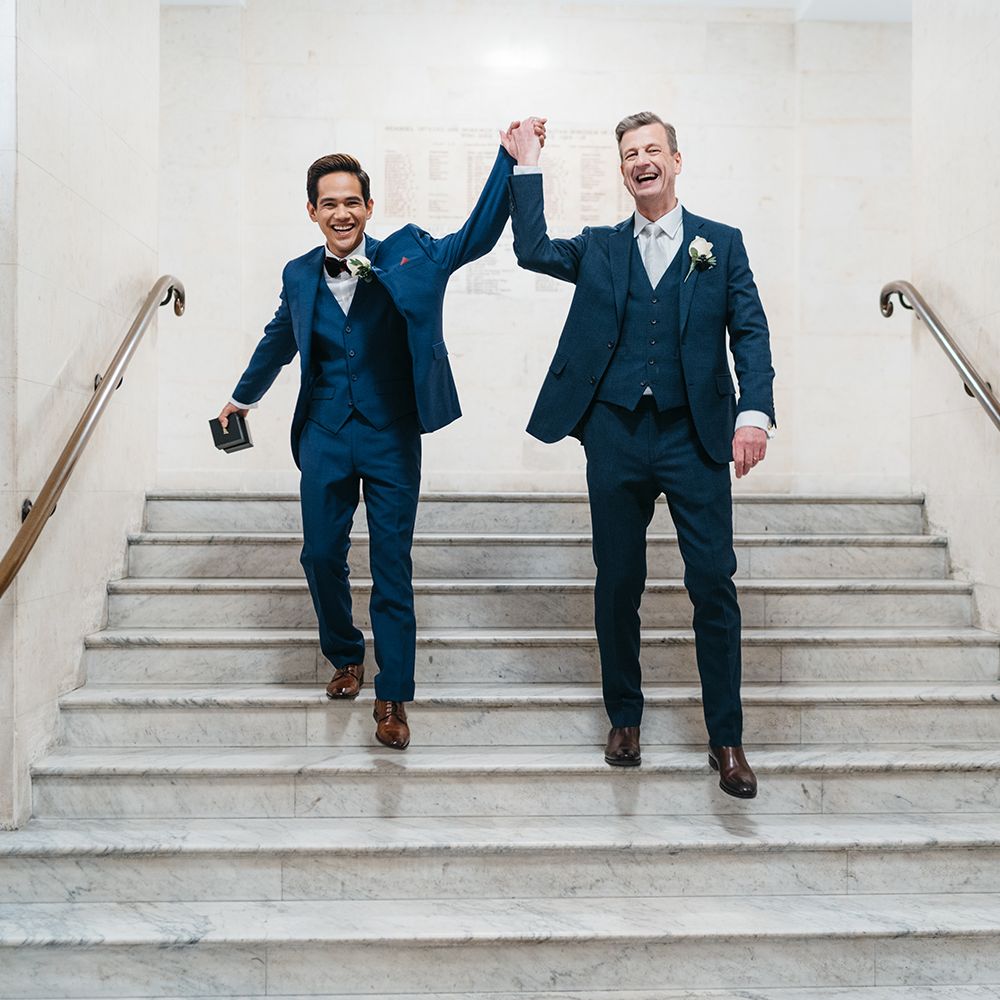 Grooms celebrate marriage whilst leaving the Old Marylebone Town Hall