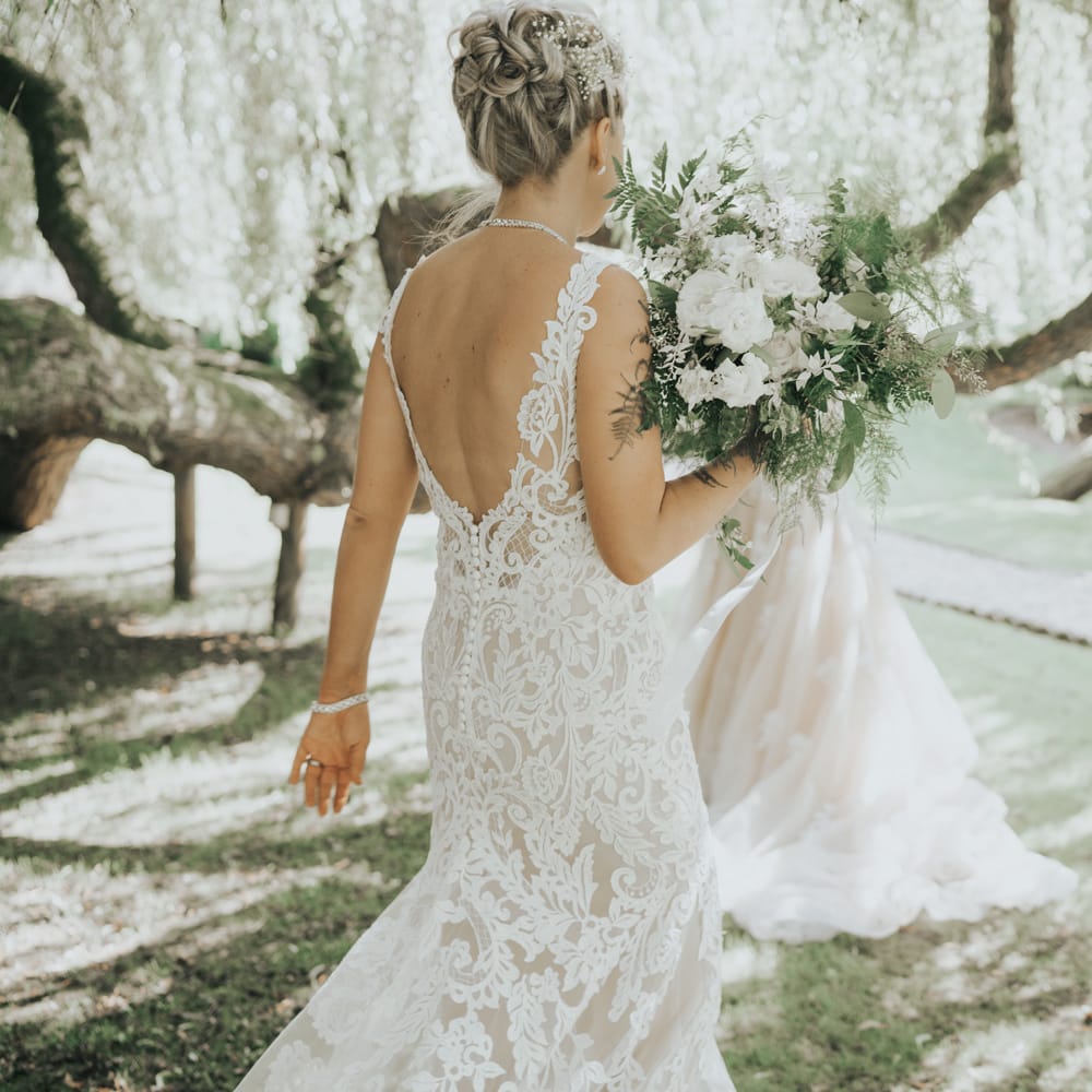 Two brides dance under the trees at Crab & Lobster fairytale wedding.