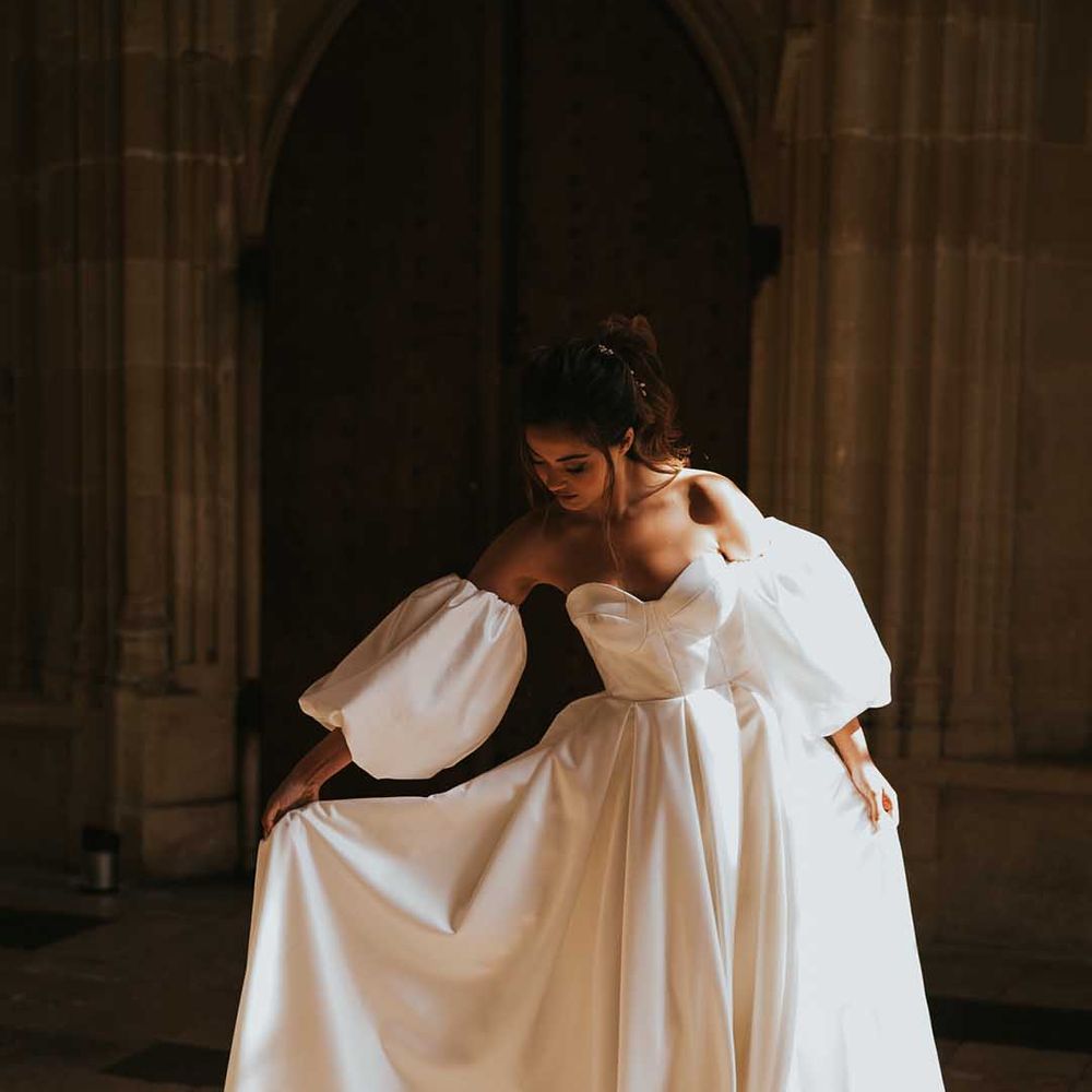 Bride in a Nortier Shallow wedding dress with strapless bodice, detachable sleeves and full skirt 