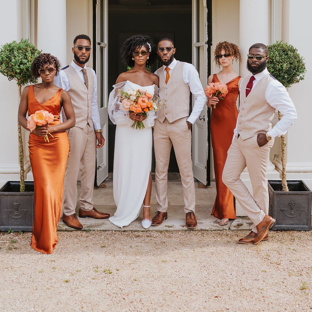 Spring wedding at Modern Hall, London with wedding party in beige suit, satin bridesmaid dresses, strapless wedding dress and sunglasses 