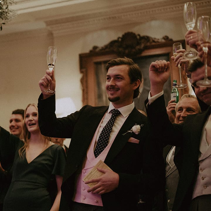 Wedding guests raising a glass at Hedsor House wedding