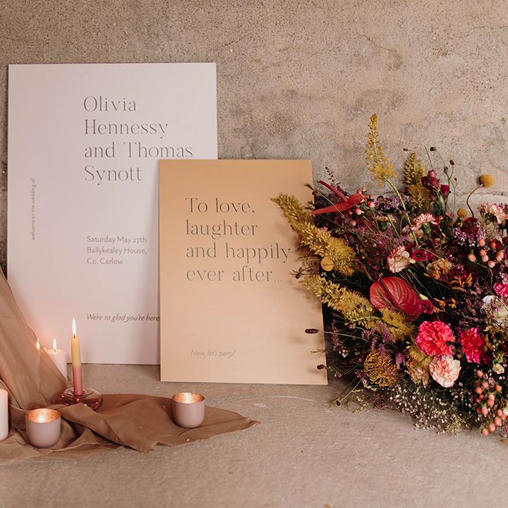 Wedding cake design and signs surrounded by candlesticks and wildflowers 