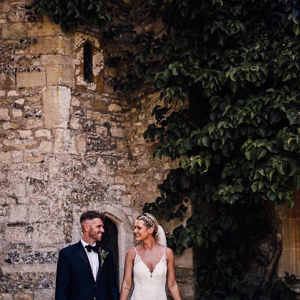 Bride and groom walk holding hands outside Athelhampton House wedding venue 