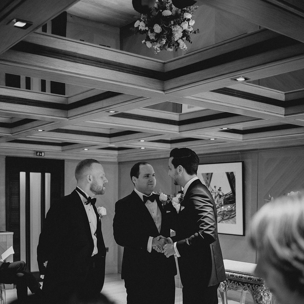 Groom speaks to and shakes hands with groomsmen 