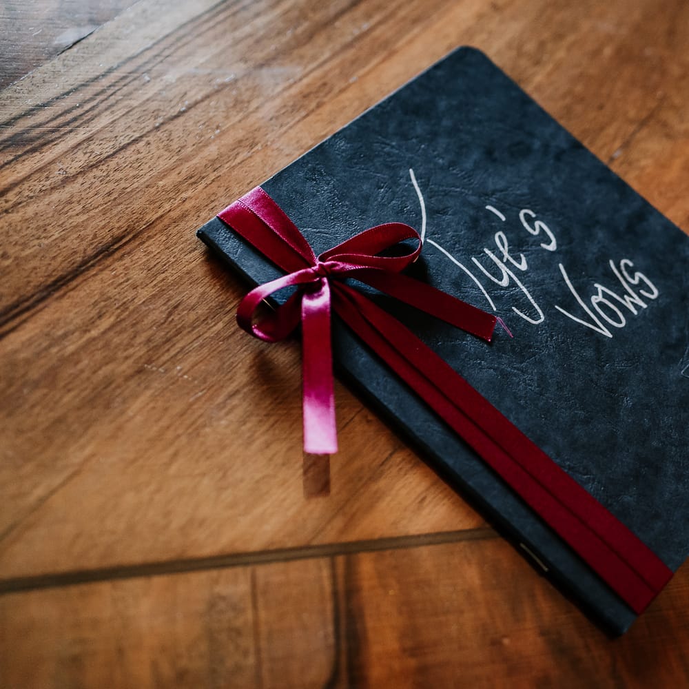 Black leather vow book complete with red ribbon to side for personal vows 