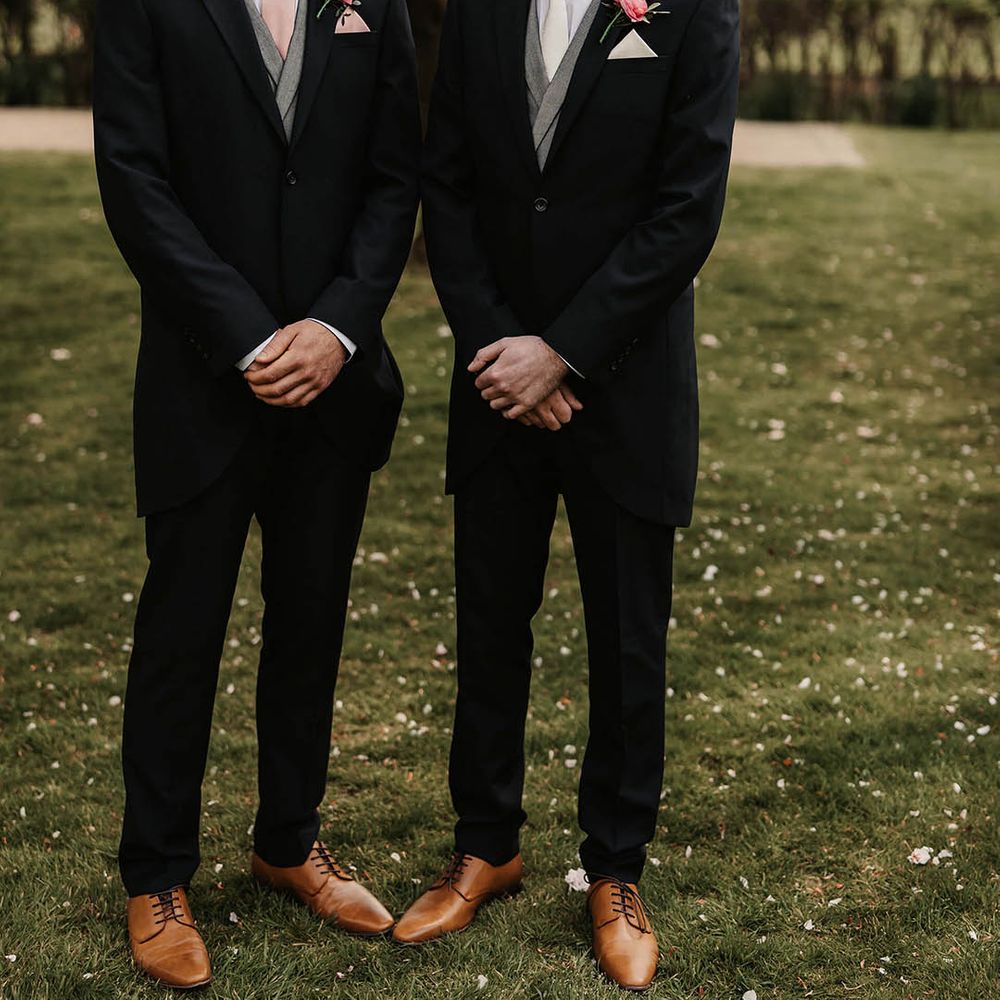 Groom and best man in morning suits, pink buttonholes and different ties and pocket squares 