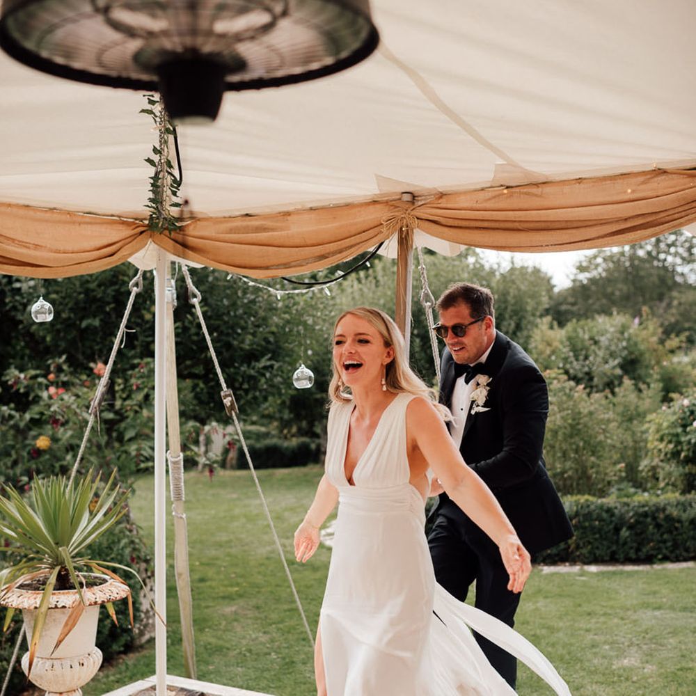 Bride and groom enter into the marquee wedding reception 